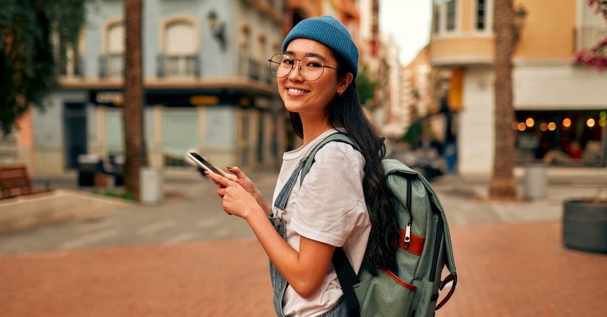 A traveller checking her phone on a sunny European street